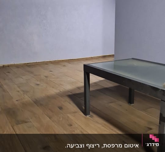 רצפת עץ אטומה עם שולחן זכוכית קטן